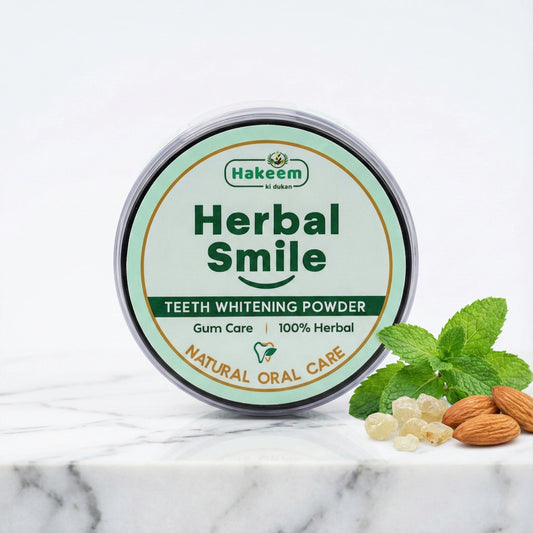 Hakeem Herbal Smile teeth whitening powder container with mint leaves and almonds on a marble surface
