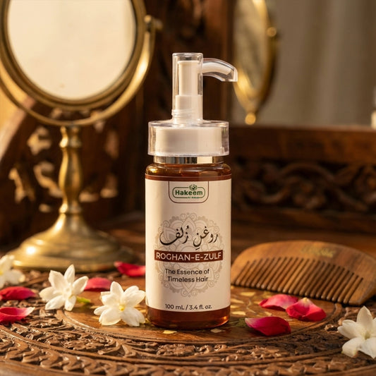 Hakeem Rochan-E-Zulf hair product bottle on a decorative wooden surface with flowers and a comb.